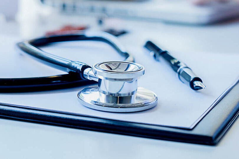 Stethoscope with clipboard and Laptop on desk Doctor working in hospital writing a prescription  Healthcare and medical concept test results in background vintage color selective focus.