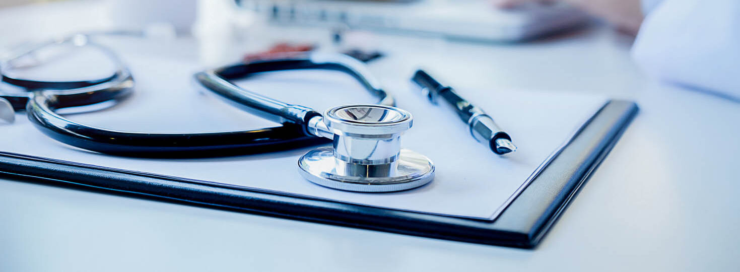 Stethoscope with clipboard and Laptop on desk Doctor working in hospital writing a prescription  Healthcare and medical concept test results in background vintage color selective focus.